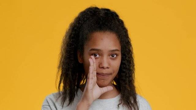 Black Girl Whispering Secrets Gesturing Finger On Lips, Yellow Background