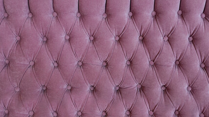 Upholstery of fashionable pink sofa close up
