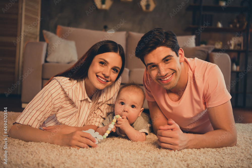 Poster Photo of candid mommy daddy newborn daughter biting toy lying floor carpet enjoy weekend on night late room apartment