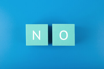 Say no or negative answer minimal concept on blue background. No written on toy cubes