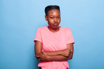 Portrait of angry african american young woman making furious expression standing in studio with...