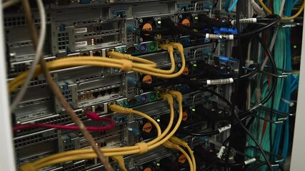 The engineer connects the cable to the system unit of a large server cabinet of the 5G network. - Powered by Adobe