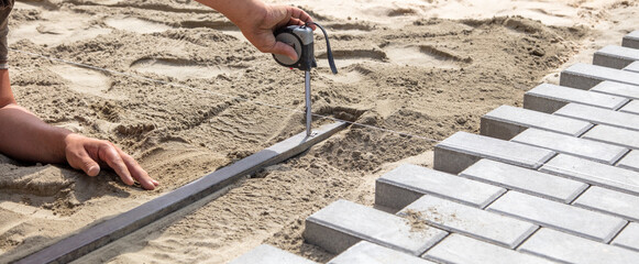 Worker measures for paving slabs.