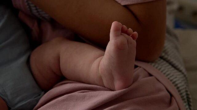 Baby Feet On Mother Hands. Cute Tiny Newborn Kid's Legs On Female Embrace Closeup. Mom And Her Child. Happy Family Concept. Beautiful Conceptual Video Of Maternity. Adorable Tiny Toes Selective Focus.