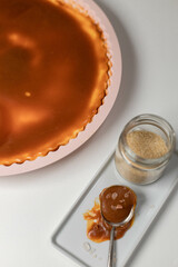 Classic cheesecake with caramel sauce on white plate on gray background. Copy space for text.