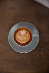 Blue cup of coffee on concrete rustic background with beautiful latte art