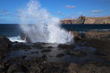 Gran Canaria, north west coast around natural swimming pools Salinas de Agaete, 
waves breaking against old eroded dark lava platform