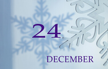 Calendar for December 24: name of the month in English, number 24 on a blue background of snowflakes and their shadows.