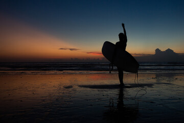 beautiful girl with a surfboard at sunset.