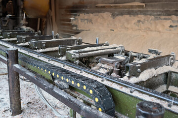 Fototapeta premium Old equipment for cutting wood at a sawmill. Woodworking industry