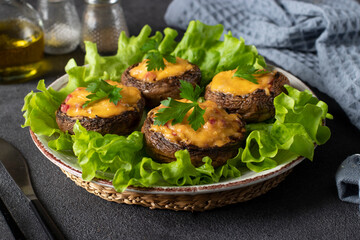 Baked champignons with sausage and cheese on gray background, hot appetizer, close-up