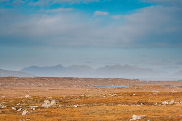 Huge fields and mountains in the background. Blue cloudy sky. Landscape scene in Connemara, county Galway, Ireland. Nobody. Warm and cool tone. Stunning nature in popular tourist region