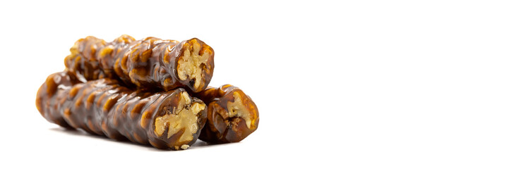 Sausage walnuts on a white background. Turkish walnut raisin sausage sweet. A sweet snack made by drying molasses and walnuts. Empty space for text. Copy space. local name ceviz sucuk