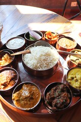 Dham - Traditional food of Himachal Pradesh. Himachali kangri dham thali includes Kaddu ka khatta, Chane ka Madra, sepu vadi, maash dal, Rajma, salad, rice, or Mitha Bhaat. served with Roti and pickle