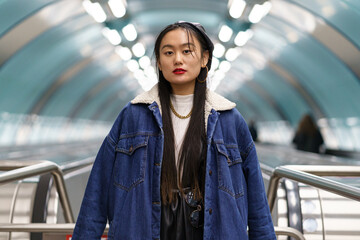 Asian girl street fashion portrait: stylish japanese female wearing jeans coat and leather beret on...