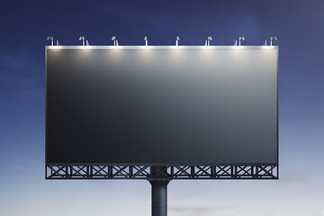 Blank black billboard on blue sky background at night, front view. Mockup, advertising concept