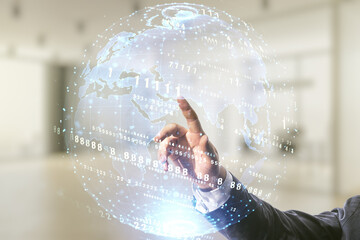 Male hand clicks on abstract virtual coding illustration and world map on blurred office...