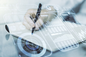Double exposure of abstract creative statistics data hologram with man hand writing in notebook on background, statistics and analytics concept