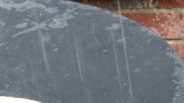 short video clip of heavy rain on a plastic table