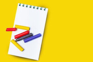 Notebook and wooden pen isolated on yellow background.Copy space