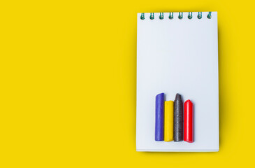 Notebook and wooden pen isolated on yellow background.Copy space