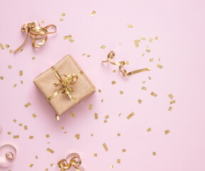 New Year and Christmas gift boxes with golden confetti on pink background, top view, flat lay, winter holidays festive concept