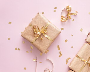 Obraz na płótnie Canvas New Year and Christmas gift boxes with golden confetti on pink background, top view, flat lay, winter holidays festive concept