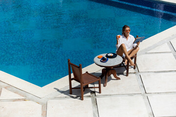 beautiful woman having breakfast near the pool.