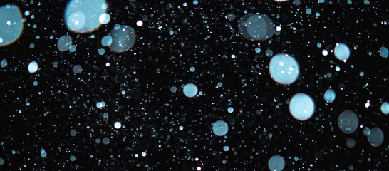 Blurred snowflakes on a dark background. Overlay image for snowfall effect