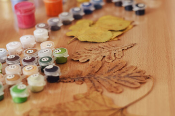 Yellow and brown Dried leaves, a set of acrylic paints and brush