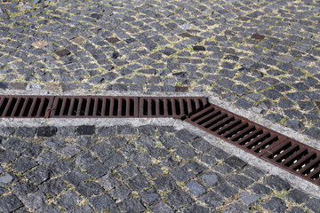 Rainwater drainage grid in a cobbled pavement