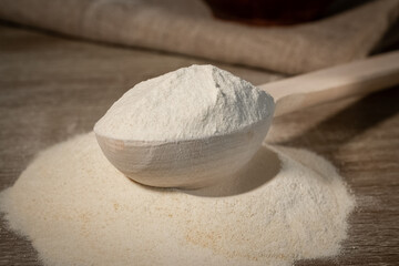 dry or powered milk in a wooden spoon