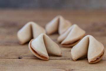 close-up of five closed chinese fortune cookies on a wooden table focus on foreground