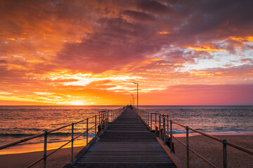 Fototapeta na wymiar Port Noarlunga beach pier with people at sunset