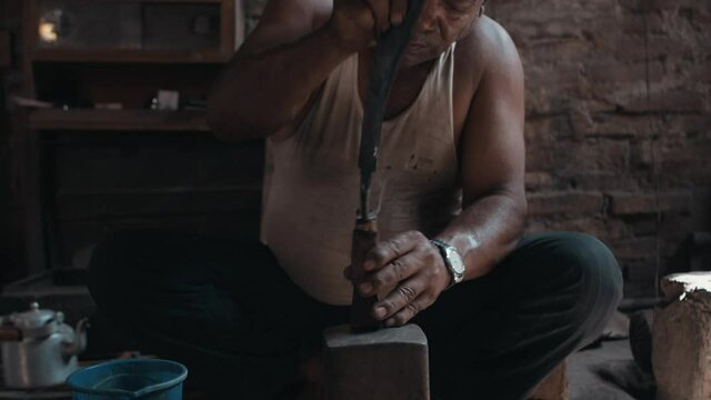 Blacksmith presses knife into knife handle, smoke flying