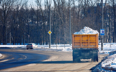 Dump truck transports snow to dump site, cleaning streets and relocation snow. Truck hauls load of...