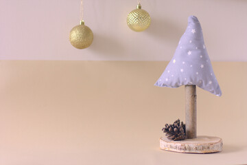 Handmade Christmas tree and golden baubles on a beige background. Copy space for Christmas greetings.