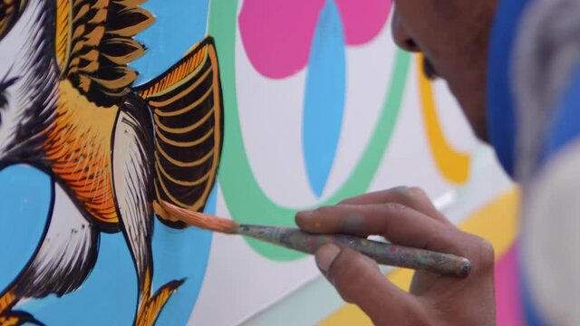 Artist painting eagle tail with golden colours