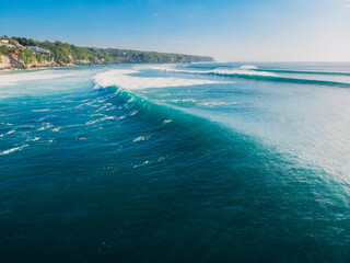 Aerial view in Bali with surfers and turquoise barrel wave.
