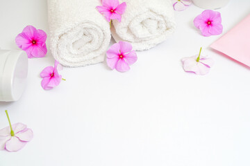 Obraz na płótnie Canvas Clean white rolled towels with flowers on white copy space for text frame