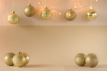 Christmas composition - golden baubles and lights on a beige background. Copy space.