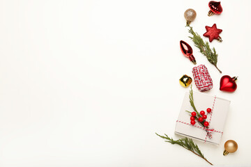 Christmas or Happy New Year composition. Fir tree branches, golden and red decorations on white background.