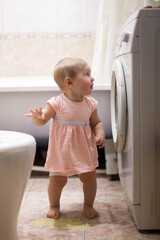 small child and  washing machine in bathroom