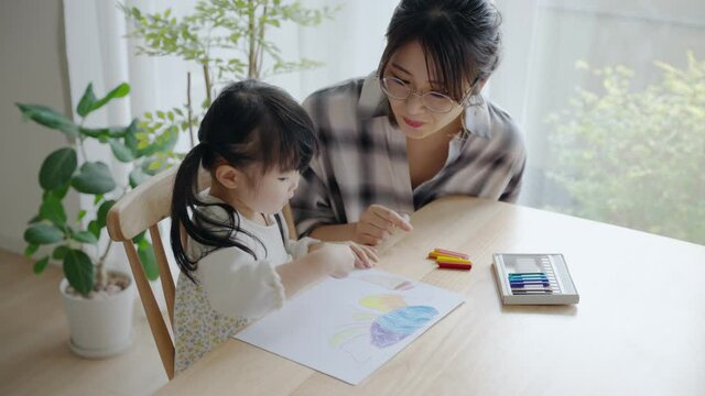家でお絵描きする3歳の子供と母親（育児・子育て）