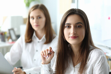 Portrait of joyful businesswoman sitting in modern workplace