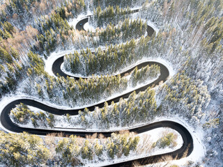 Winding road through the forest, from high mountain pass, in winter time