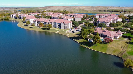 Top view waterfront apartment building with landfill community waste disposal in background near Dallas, Texas