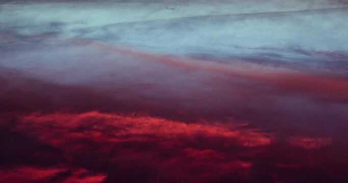 Intense colors of blood red pink blue cloud formations