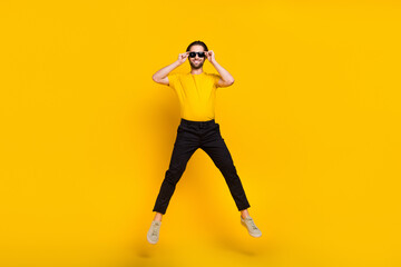 Fototapeta na wymiar Full body photo of young cheerful man good mood jumper eyewear wear casual outfit isolated over yellow color background