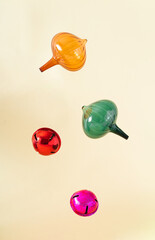 Christmas vintage ornaments in orange, green, red and pink colour behind pastel beige champagne background. Winter holidays and New Year ornaments layout. Retro 80s or 90s aesthetic.